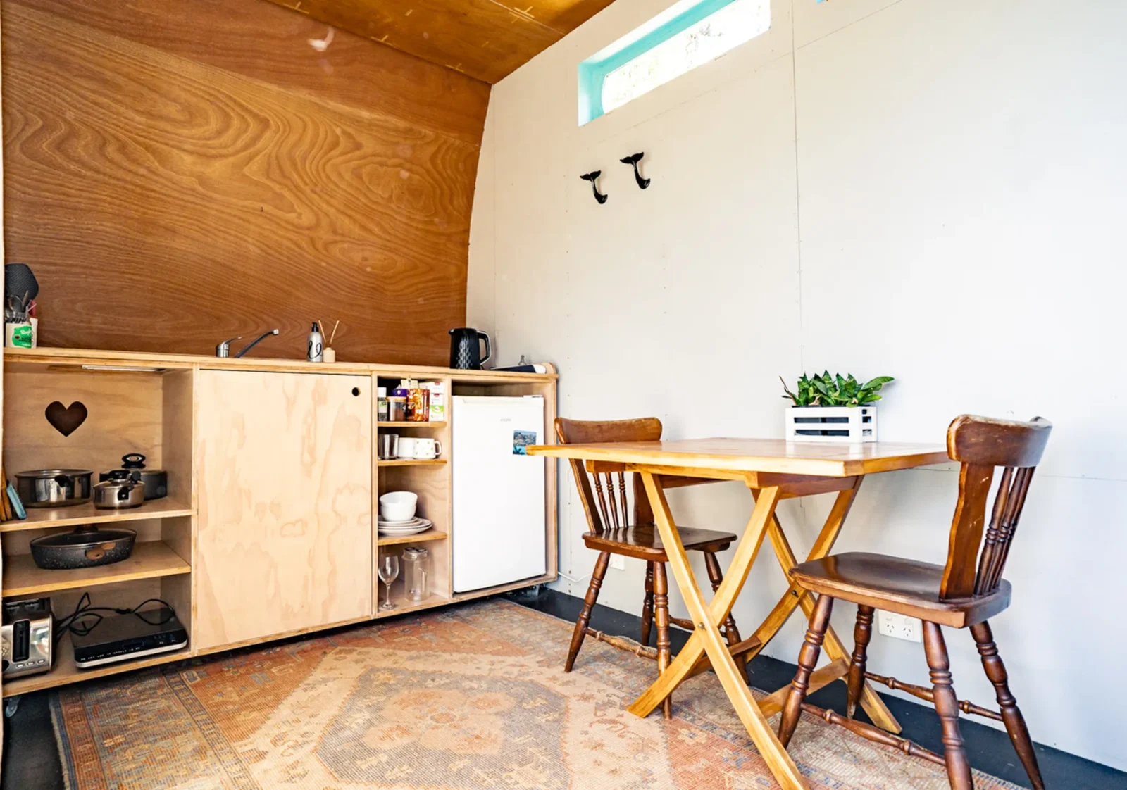 Dining area with timber furniture in Kauri cabin at Totara Enclave