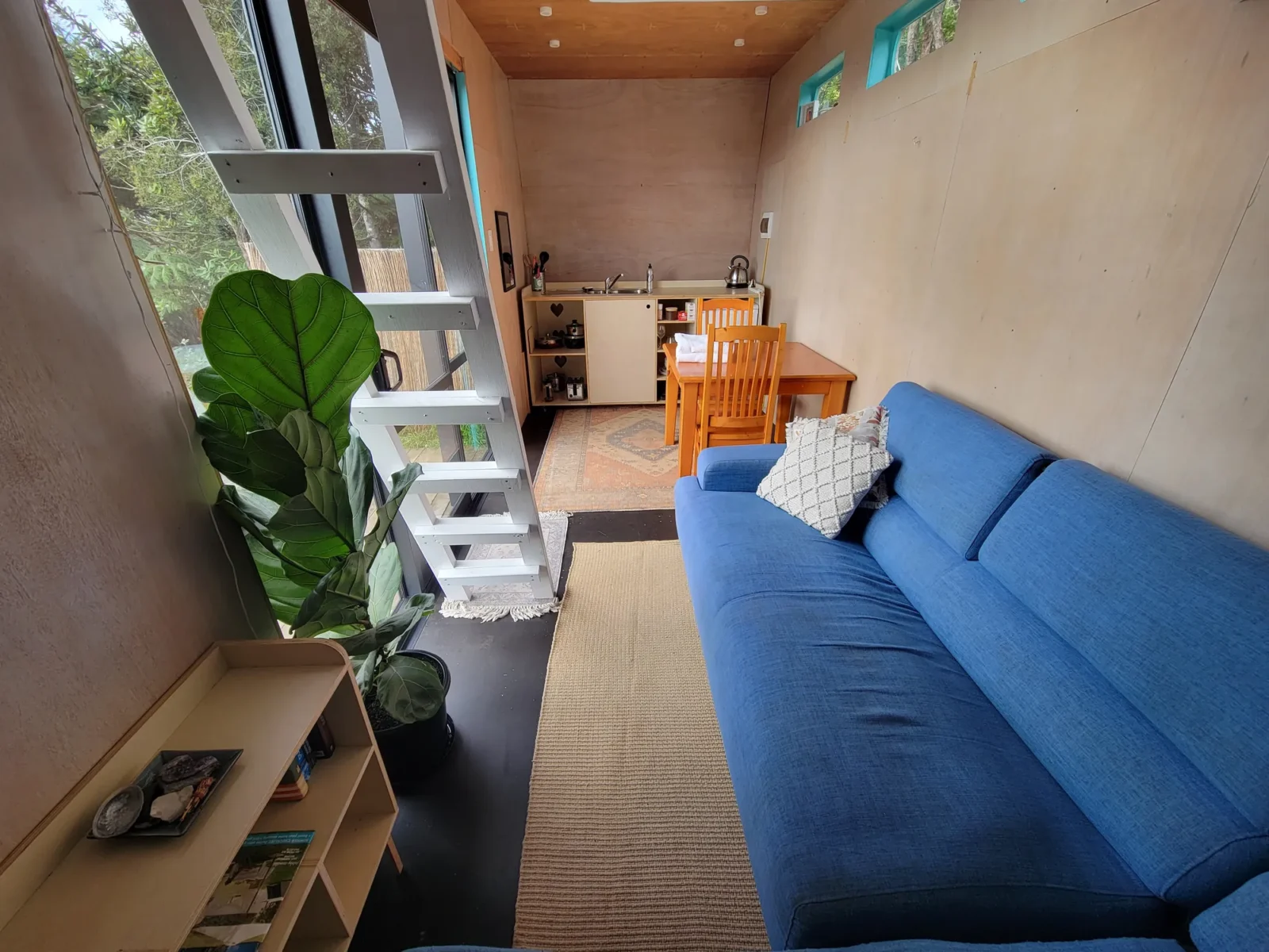 Living area with blue sofa in Kowhai cabin at Totara Enclave